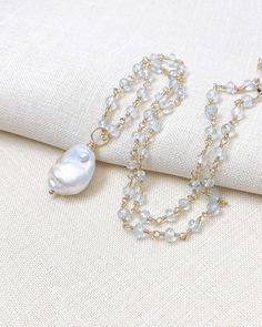 Indulge in the luxurious laid-back vibe of this magnificent baroque pearl pendant necklace. Each component of this exquisite piece of jewelry has been handcrafted with great care and attention to detail, resulting in a unique and breathtakingly beautiful design. The pearl's distinctive shape and beauty have been carefully selected to ensure it exudes a sense of elegance and sophistication. The artisan's meticulous wire-wrapping process of each small aquamarine gemstone adds a touch of perfection Luxury Baroque Pearl Charm Jewelry, Luxury Jewelry With Baroque Pearl Drop, White Baroque Pearl Long Necklace, Luxury Handmade Teardrop Necklaces, Bohemian Pendant Necklace With Pearl Charm, Elegant Baroque Pearl Teardrop Pendant Jewelry, Elegant Oval Pendant Necklace With Natural Stones, Luxury Handmade Teardrop Necklace, Bohemian Pearl Necklace With Pearl Charm