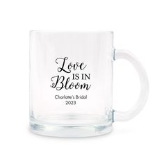 a glass mug with the words love is in bloom on it