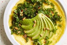 a white bowl filled with hummus and avocado