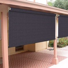 an awning on the side of a building with a brick sidewalk and trees in the background