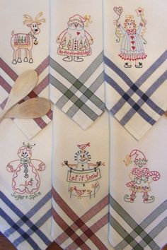 four white handkerchiefs with embroidered designs on them and a wooden spoon in the middle