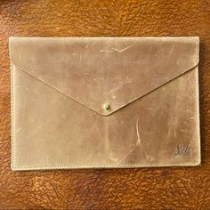 a brown leather envelope sitting on top of a wooden table