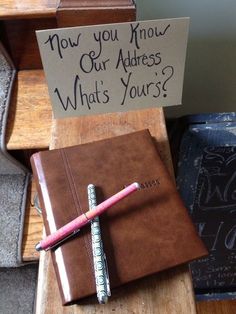 a notepad and pen sitting on top of a wooden desk next to a sign