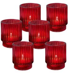 four red glass candlesticks sitting next to each other