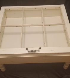 an old window is turned into a coffee table with drawers and knobs on each side