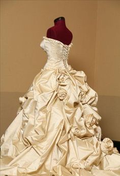 a wedding dress is displayed on a mannequin