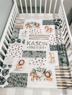 a baby crib with a blanket that says kasson bricks on it and animals