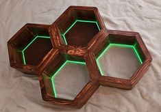 three hexagonal wooden trays with green light in them on a white sheet