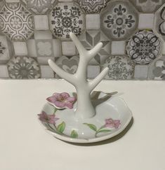 a white plate with pink flowers on it and a tree shaped bowl in the middle