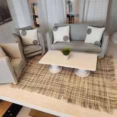 a living room with couches, chairs and a coffee table in the middle of it