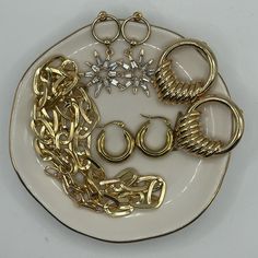 a white plate topped with lots of gold jewelry