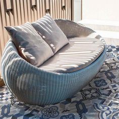 a round couch sitting on top of a blue and white rug