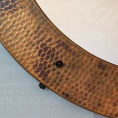 a close up of a metal object with holes in it's center and some black dots on the bottom