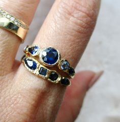 Journey to a blue haven of deep-sea blues to sky blues with this one-of-a-kind Journey Sapphire Ring customized around a set of starry sapphires. 14k yellow gold. Round brilliant blue sapphire center measures 5mm. Round brilliant, pear-shaped, marquis blue sapphire side stones. 1.3 total carat weight. Currently a size 7. It can be resized to your preferred size. Please enter your specific ring size in the Add Order Notes section at check out. Heirloom Blue Sapphire Diamond Ring, Blue Sapphire Ring With Rose Cut Diamonds For Anniversary, Blue 14k Gold Sapphire Ring With Rose Cut Diamonds, Blue Round Sapphire Ring With Rose Cut Diamonds, Anniversary Blue Sapphire Ring With Rose Cut Diamonds, Heirloom Blue Sapphire Ring With Rose Cut Diamonds, Faceted Sapphire Ring In Fine Jewelry Style, Multi-stone Sapphire Ring In Yellow Gold, Luxury Blue Sapphire Ring With Bezel Setting