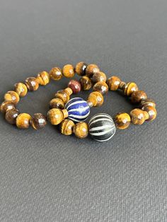 Tigers Eye Unisex Bracelet With Black & White Java Focal Bead - Etsy Artisan Adjustable Bracelets With Round Beads, Artisan Hand Wrapped Black Bracelets, Everyday Artisan Beaded Bracelets, Artisan Hand Wrapped Black Bracelet, Artisan Hand-wrapped Black Bracelet, Artisan Bracelet With Round Beads For Everyday, Brown Hand Wrapped Stretch Bracelet Gift, Brown Hand Wrapped Stretch Bracelet For Gift, Artisan Wooden Beads Stretch Bracelet