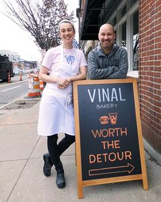 two people standing next to a sign that says,'worth the detour '