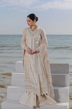 Description: This exquisite ivory 3 piece lawn Pakistani women's outfit from Qalamkar is the epitome of elegance and sophistication. The embroidered kurta is a stunning work of art, featuring intricate embroidery and delicate details. The outfit is completed with a dupatta and wide leg plain lawn trouser. Materials: Shirt (Lawn) - Chikankari Gotta Embroidered with digital printingDupatta (Organza) - Embroidered Dupatta with laceTrouser (Lawn) - Plain Trouser *Disclaimer: Due to the many variations in monitors and browsers, the color of products may appear different on different monitors. **Additional decorative trim has been added to the outfit in the photos. The stitched outfit will not include the additional designer trim. Expensive Suits, Wedding Dress Suit, Pakistani Clothes Online, Pakistani Dresses Online, Partywear Dresses, Embroidered Border, Embroidered Dupatta, Lace Neckline, Suit Fabric