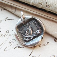 a wax seal with a ship on it sitting on top of an old piece of paper