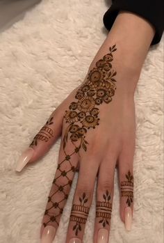 a woman's hand with henna tattoos on it