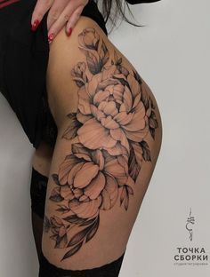 a woman's thigh with flowers on it and her hand resting on the leg