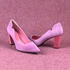 a pair of pink high heeled shoes sitting on top of a pink carpet covered floor