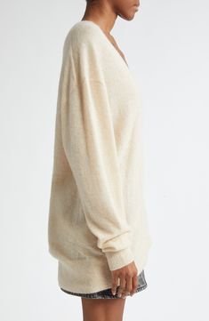 A fine blend of silk, alpaca and cashmere softens this oversized sweater knit with dramatically dropped shoulders and a deep V-neck. Deep V-neck Long sleeves Dropped shoulders Ribbed cuffs and hem 37% silk, 32% baby alpaca, 31% cashmere Dry clean Imported Designer Clothing Oversized Cream V-neck Sweater, Cream Cashmere V-neck Sweater, Oversized Cashmere Cardigan In Fine Knit, Oversized Cashmere Cardigan With Fine Knit, Oversized Fine Knit Cashmere Cardigan, Elegant Oversized V-neck Sweater, Cozy Cashmere V-neck Sweater In Fine Knit, Cozy Cashmere V-neck Fine Knit Sweater, Oversized V-neck Cashmere Cardigan