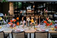 the table is set with flowers and candles