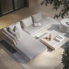 a white couch sitting on top of a hard wood floor next to a coffee table