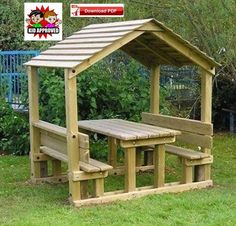 a wooden picnic table and bench in the grass