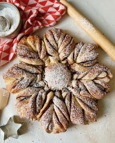 a pastry with powdered sugar on top next to baking utensils