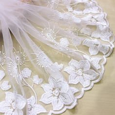 white lace with flowers and feathers on a table