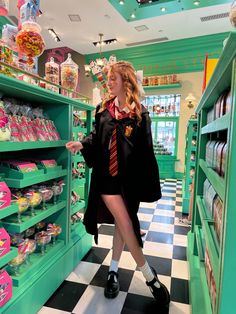 a woman in a harry potter costume is standing by shelves with candy and candies