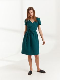 "FLORA is a true wrap linen dress with side seam pockets. DETAILS - True wrap dress - Below the knee length - Smock silhouette - Short sleeve - Side seam pockets - Oeko-Tex certified 100% midweight linen - Cut and sewn to order just for you in our studio COLOR - Emerald Blue, you can also choose other colors above - Fabric samples are available here https://www.etsy.com/listing/586569696/linen-fabric-samples SIZING & FIT - Fits true to size - Model is wearing a size XS - Model is 5'8.9\" / 1 V-neck Linen Dress For Workwear With Relaxed Fit, Relaxed Fit Linen V-neck Dress For Work, Knee-length Linen Dress With Tie Waist, Knee-length Belted Fitted Linen Dress, Fitted Knee-length Belted Linen Dress, Fitted Knee-length Linen Dress With Belt, Relaxed Fit V-neck Linen Dress For Work, Linen V-neck Dress For Work, Linen Tie Waist Dress For Work