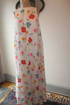 This pretty cotton sleeveless floral maxi dress by Saks Fifth Avenue is perfect for summer days.  Lovely floral pattern with little daisy trim around the neckline and arm holes.  It opens in the back with a 21 inch covered zipper, is fully lined, and has two side pockets.  It looks great worn as is or belted.  The garment may be hand washed or dry cleaned per the label.  No size label, but best suited for medium frames.  Measurements laid flat are: neckline/shoulders 11 inches, arm opening 9 inc Summer A-line Floral Day Dress, Spring Lined Cotton Maxi Dress, Spring Cotton Lined Maxi Dress, Sundress With Ditsy Floral Print Maxi Length, Summer Floral Print A-line Maxi Dress, Summer Floral Long Dress Printed, Summer A-line Floral Lined Dress, Summer Floral A-line Dress, Summer Floral Midi Dress For Daywear