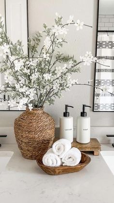 a bathroom with white towels and flowers in a basket