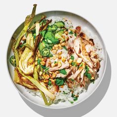 a white bowl filled with rice, meat and veggies on top of it