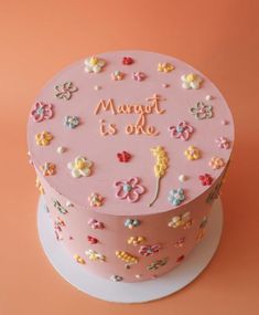 there is a pink cake with flowers on the top that says marott is one