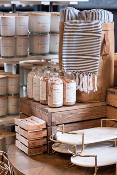 many jars are stacked on top of each other in front of some wooden boxes and baskets