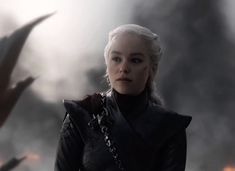 game of thrones character daeneria starke standing in front of flames