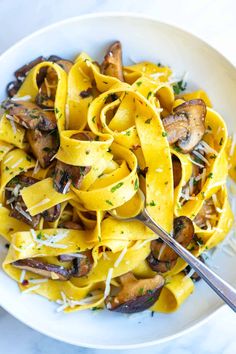 a white bowl filled with pasta and mushrooms