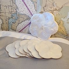 a pile of white plates sitting on top of a bed next to a map wall