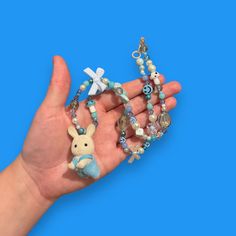 Bring some whimsy to your outfit with our Critter Bead Necklace, adorned with a charming Calico Critter. Each necklace is one-of-a-kind, handmade in Manchester, UK with varying colors and beads for a unique touch. Elastic thread and a clasp closure make it easy to wear. Blue Beaded Charm Necklaces With Round Beads, Handmade Adjustable Whimsical Charm Necklace, Cute Blue Necklace For Gift, Whimsical Blue Charm Necklace As Gift, Whimsical Blue Charm Necklace For Gift, Playful Blue Beaded Jewelry, Cute Blue Necklace With Colorful Beads, Blue Beaded Chain Charm Necklace As Gift, Playful Blue Round Bead Jewelry