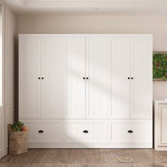 an empty room with white cabinets and wood floors