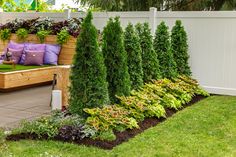 a wooden bench sitting next to a lush green garden