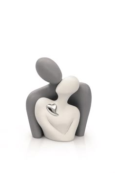 a white and gray figurine sitting next to each other on a white surface