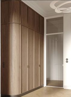 an empty room with wooden closets and white walls, along with wood flooring