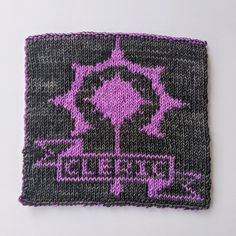 a purple and black knitted square on a white surface with the words delectary written across it