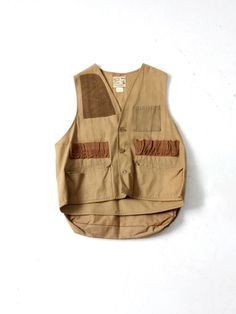 This is a 1970s vintage Nesco "Hunting Apparel" vest. The canvas duck hunting vest features a rifle pad at the shoulder, ammo pockets, and a large back nylon game pocket.  CONDITION In good condition with wear consistent with age and use.  MARKED SIZE: L MEASUREMENTS Bust: 46"  ..   116.8 cm Length: 23.5"  ..  59.7 cm Shoulders: 14.5"  ..  36.8 cm 424355 Hunting Apparel, Camo Vest, Hunting Vest, Mens Vests, Duck Hunting, Hunting Clothes, Vest Outfits, Outdoor Wear, Western Outfits