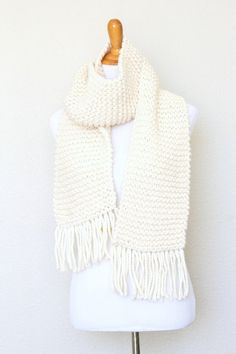 a white knitted scarf on a mannequin