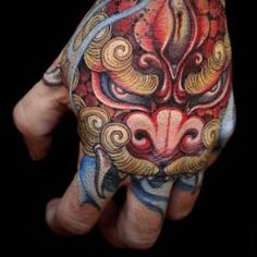 a person's hand with a tattoo on it and an animal head in the middle